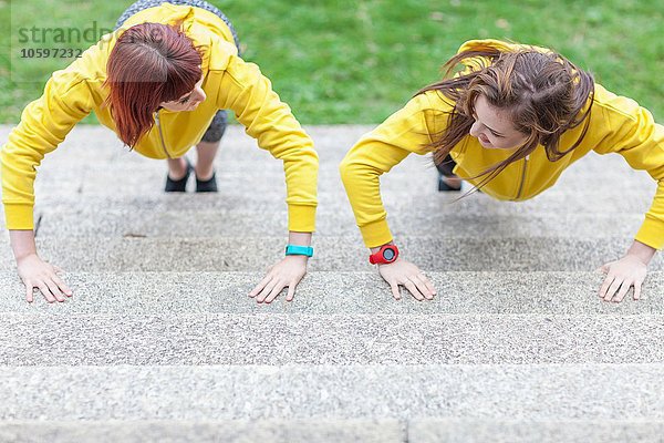 Junge Frauen beim Liegestütz auf der Treppe