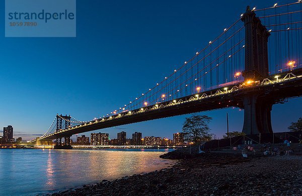 Manhattanbrücke vom Flussufer bei Nacht  New York  USA