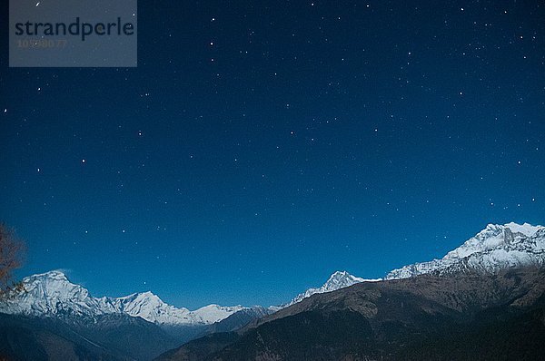 Schneebedeckte Bergkette unter Sternenhimmel  Nepal