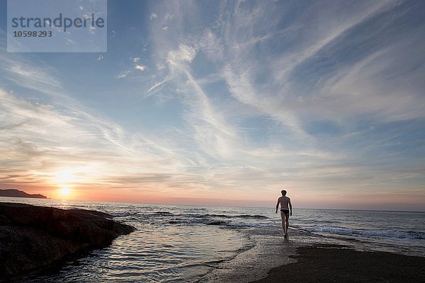 Rückansicht des reifen Mannes am Strand bei Sonnenuntergang  Calvi  Korsika  Frankreich