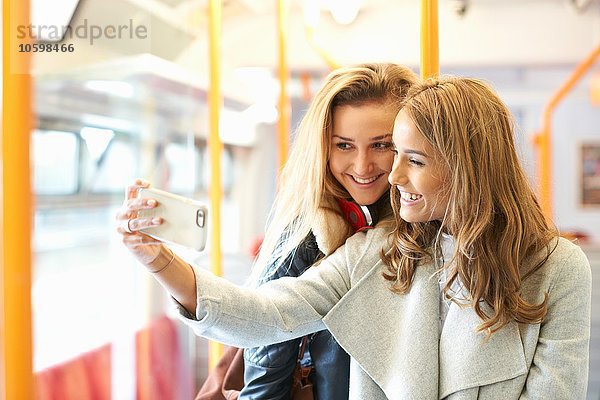 Zwei junge Freundinnen im Zug  Selbstporträt  mit Smartphone