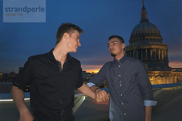 Zwei junge Männer  die nachts vor St. Pauls Händchen halten  London  UK