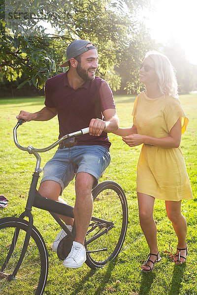 Junges Paar beim Radfahren im sonnigen Park