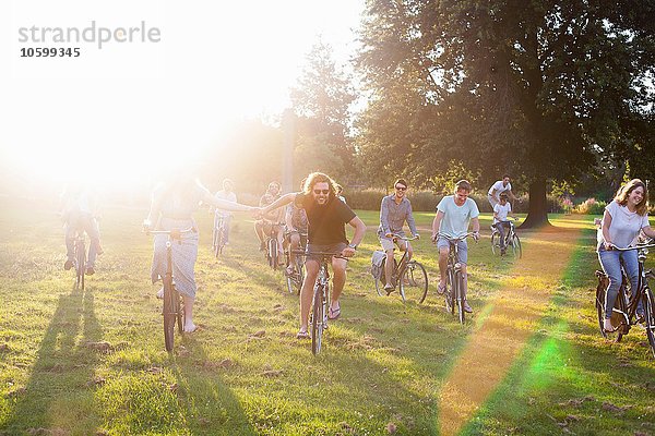 Massen von erwachsenen Freunden  die mit dem Fahrrad zum Sonnenuntergang anreisen.