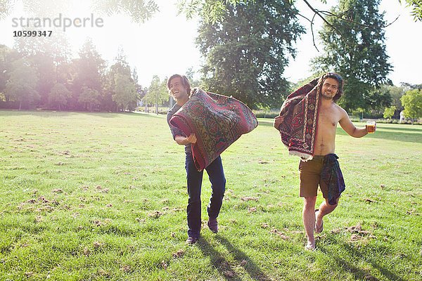 Zwei junge Männer mit Teppichen für die Sunset-Park-Party