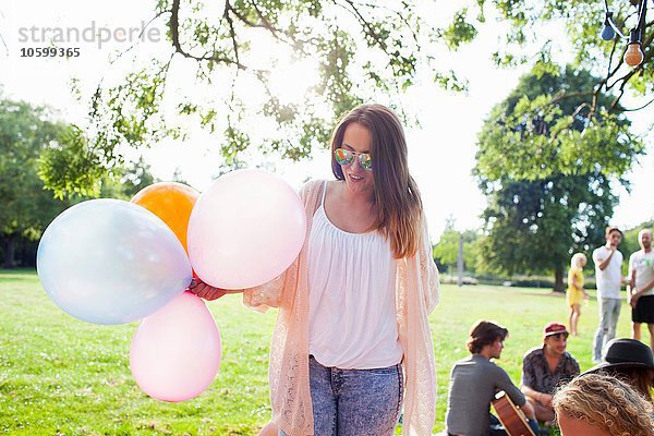 Junge Frau mit Luftballons auf der Parkfeier