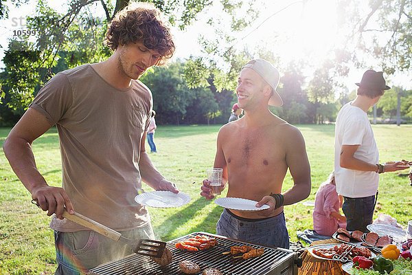 Junge Männer grillen auf der Sunset Park Party