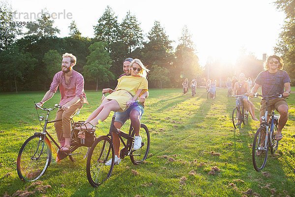 Massen von Erwachsenen  die mit dem Fahrrad zum Sonnenuntergang anreisen.