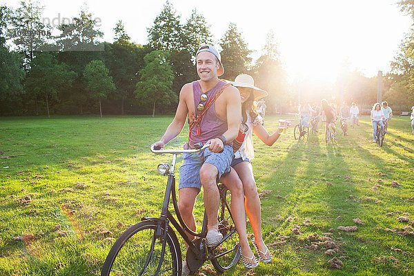 Massen von Erwachsenen  die mit dem Fahrrad zum Sonnenuntergang anreisen.