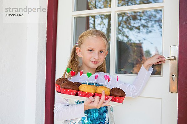 Porträt eines Mädchens mit Kuchen auf der Terrasse