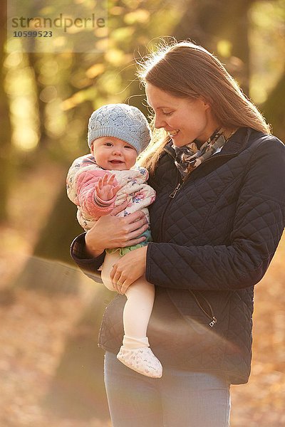 Porträt der mittleren erwachsenen Frau und der kleinen Tochter im Herbstpark