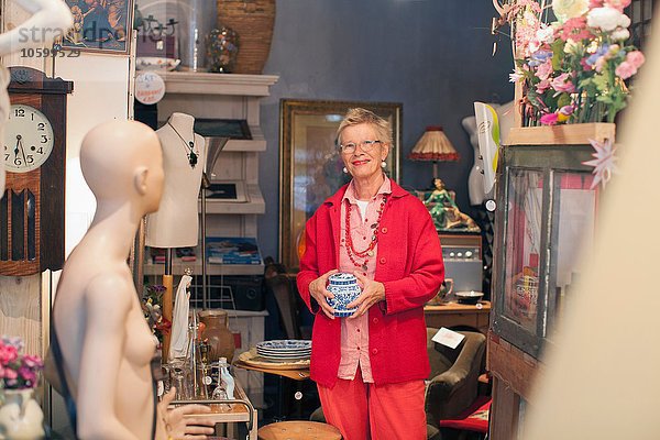 Porträt einer reifen Frau mit Porzellantopf im Vintage-Shop