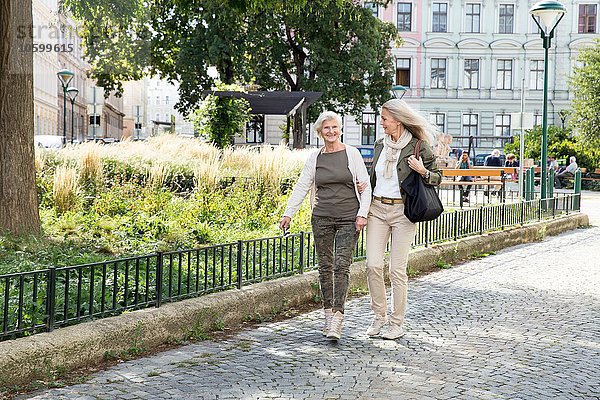 Mutter und Tochter gehen gemeinsam die Straße entlang.