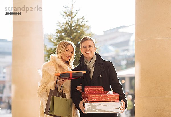 Porträt eines jungen Paares mit Weihnachtsgeschenken in Covent Garden  London  UK