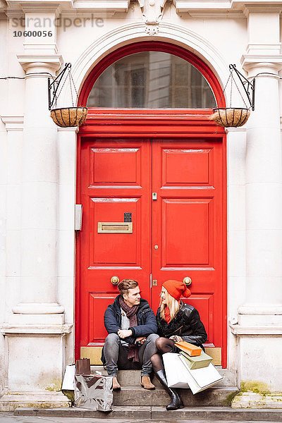 Junges Einkaufspaar macht Pause vor der Haustür  London  UK