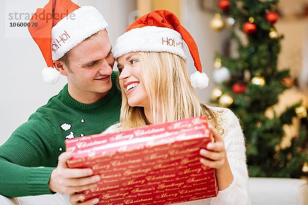 Romantisches junges Paar mit Weihnachtsgeschenk