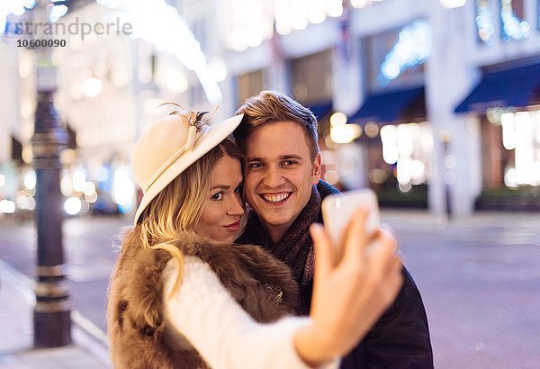 Junges Paar nimmt Smartphone Selfie an Weihnachten in der New Bond Street  London  UK