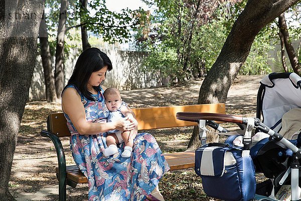 Großmutter sitzend auf Parkbank mit Baby-Enkelin