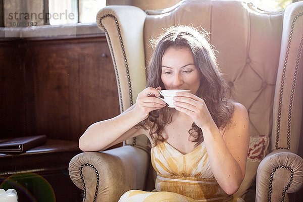Frau trinkt eine Tasse Tee im alten Sessel im Thornbury Castle  South Gloucestershire  UK