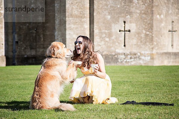 Frau posiert mit Tasse Tee und Golden Retriever Hund im Thornbury Castle  South Gloucestershire  UK
