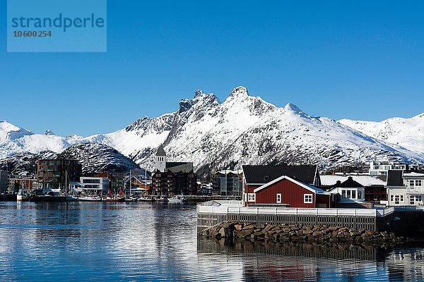 Blick auf Häuser am Wasser und schneebedeckte Berge  Svolvaer  Lofoten  Norwegen