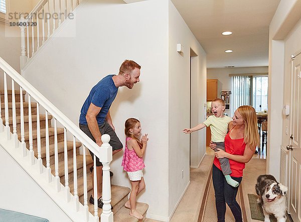 Familie spielt Peek-a-boo auf der Treppe zu Hause