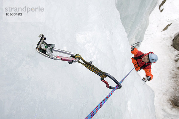 Junger Mann beim Eisklettern