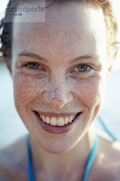 Porträt einer sommersprossigen jungen Frau  die lächelt