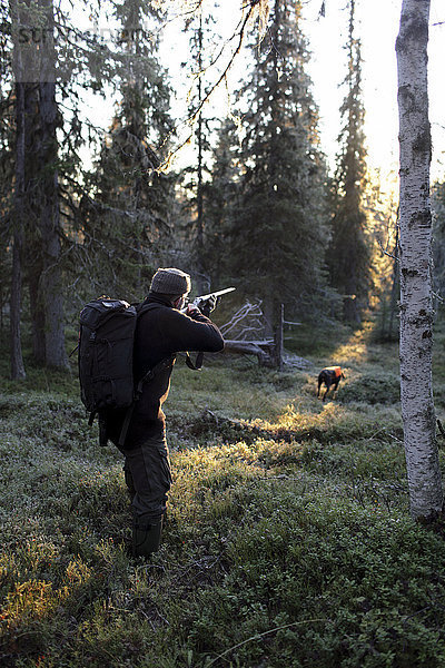 Junger Mann auf der Jagd mit Hund