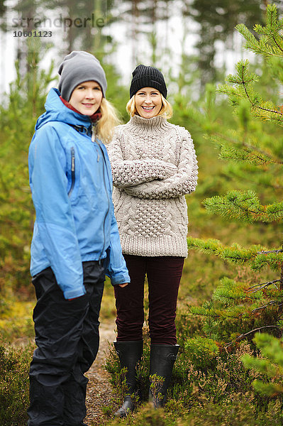 Zwei lächelnde Frauen stehen im Wald