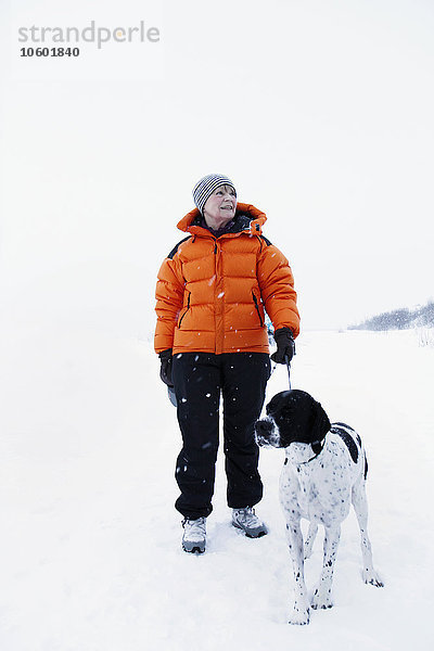 Frau führt Hund im Winter aus