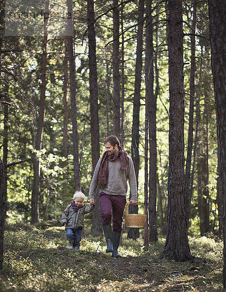 Vater geht mit Sohn durch den Wald