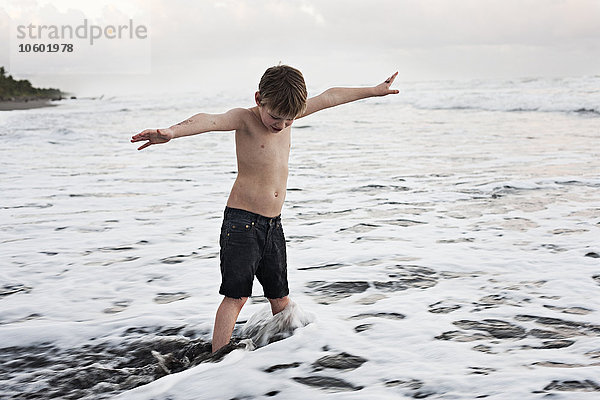 Junge spielt im Meer