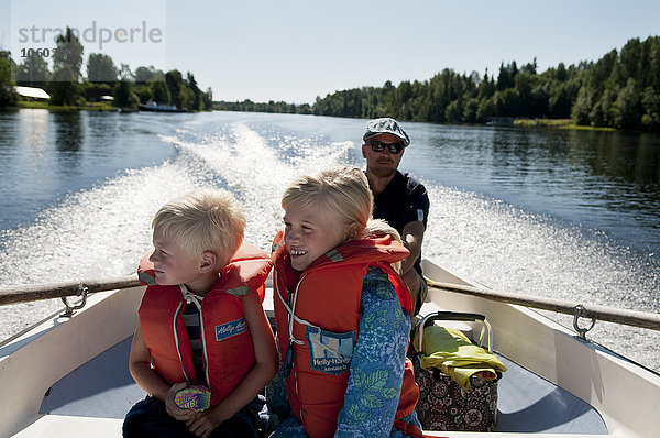 Vater mit Kindern auf Boot