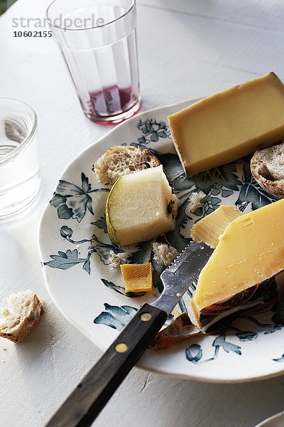 Hoher Blickwinkel auf Käse auf einem Teller und ein Glas Wein