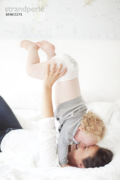 Mutter spielt mit Sohn auf dem Bett