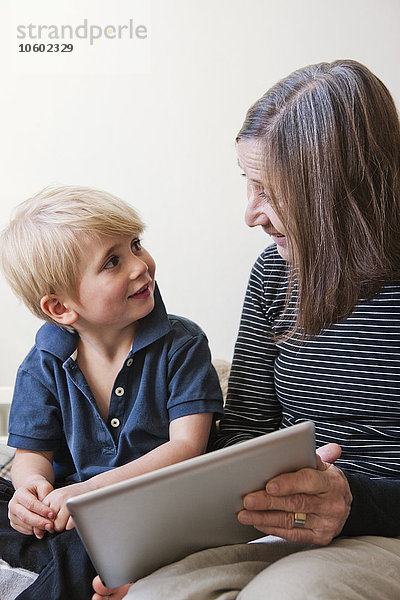 Großmutter und Enkel benutzen ein digitales Tablet