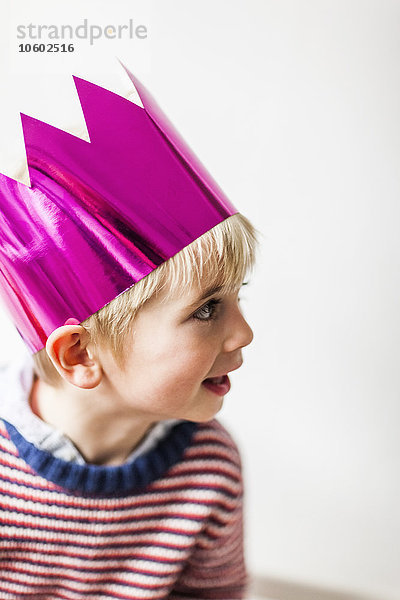 Porträt eines Jungen mit Papierkrone  Studioaufnahme