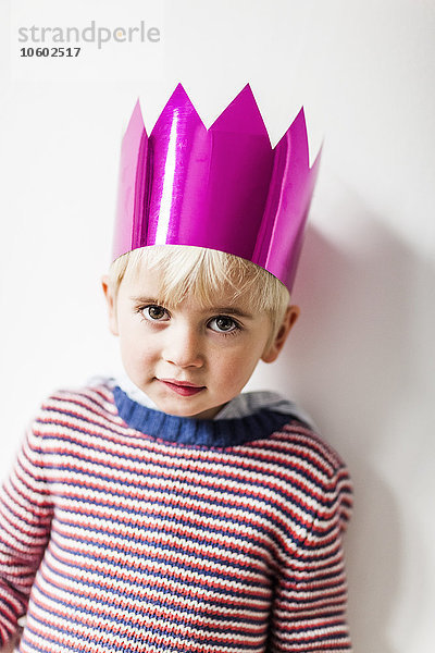 Porträt eines Jungen mit Papierkrone  Studioaufnahme