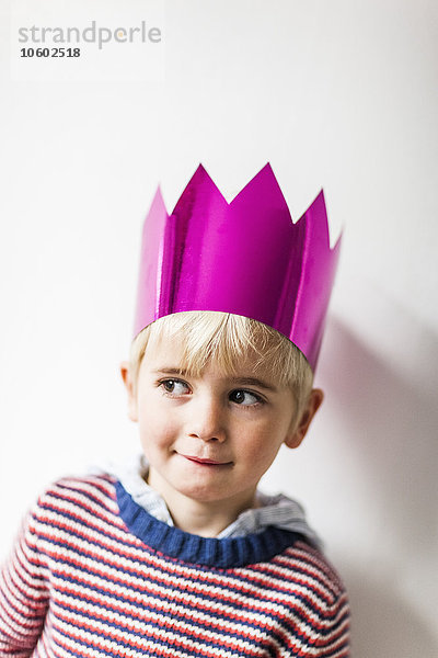 Porträt eines Jungen mit Papierkrone  Studioaufnahme