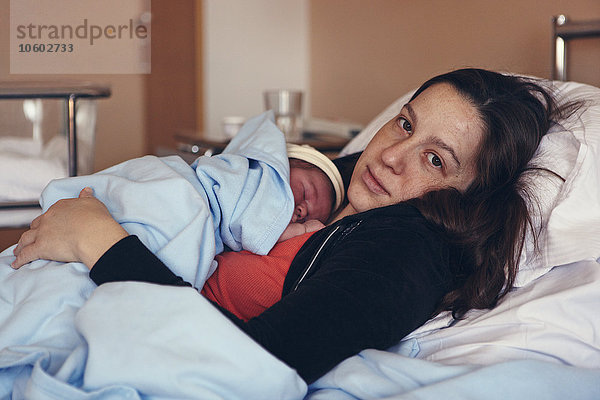 Mutter mit neugeborenem Baby im Krankenhausbett