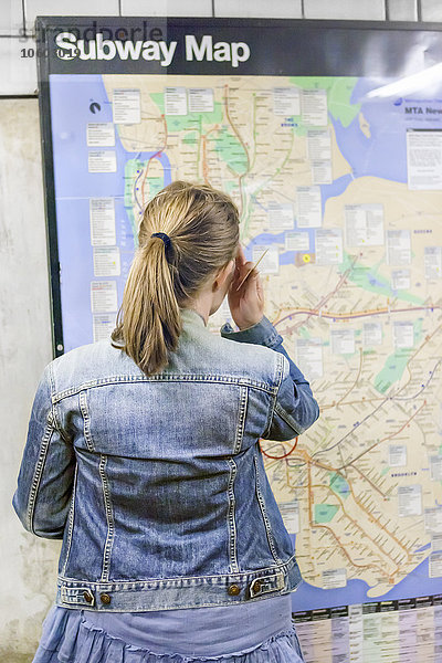 Frau schaut auf U-Bahn-Karte