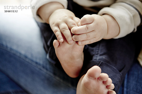 Babys Hände halten Füße