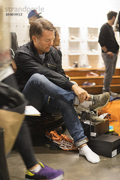 Mann probiert Schuhe im Geschäft