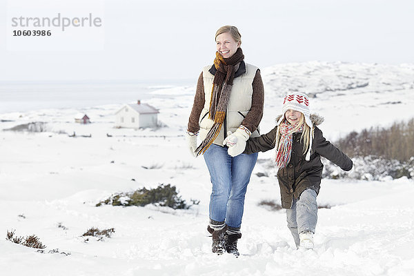 Frau geht mit Tochter im Winter spazieren