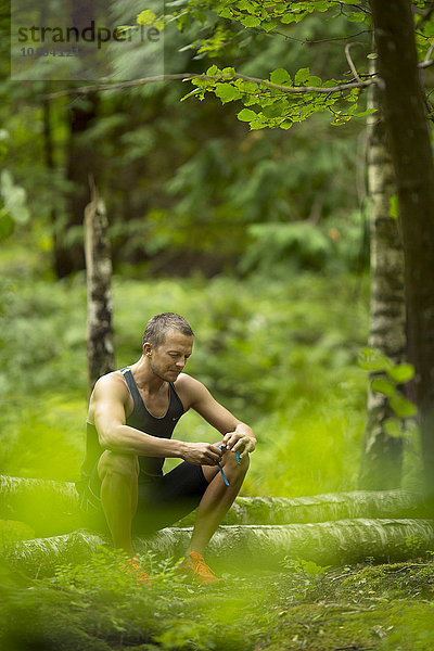 Mann sitzend im Wald