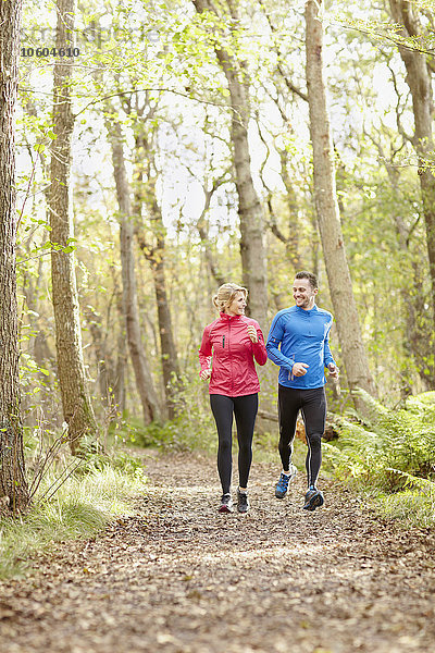 Junges Paar joggt durch den Wald