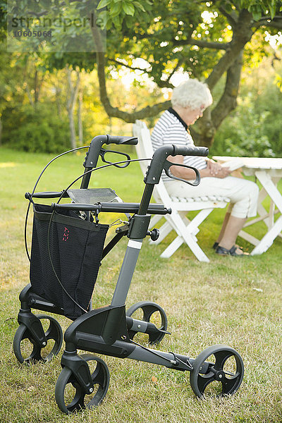 Gehgestell  Frau im Garten im Hintergrund