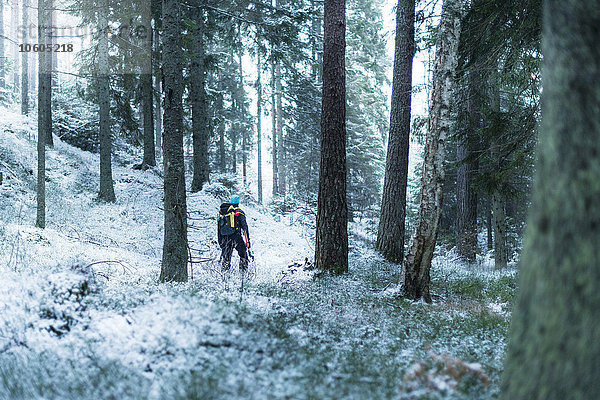 Mann geht durch Winterwald