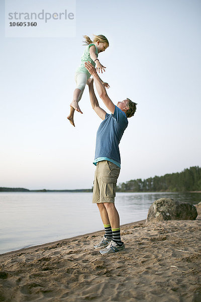 Vater spielt mit Tochter am Strand